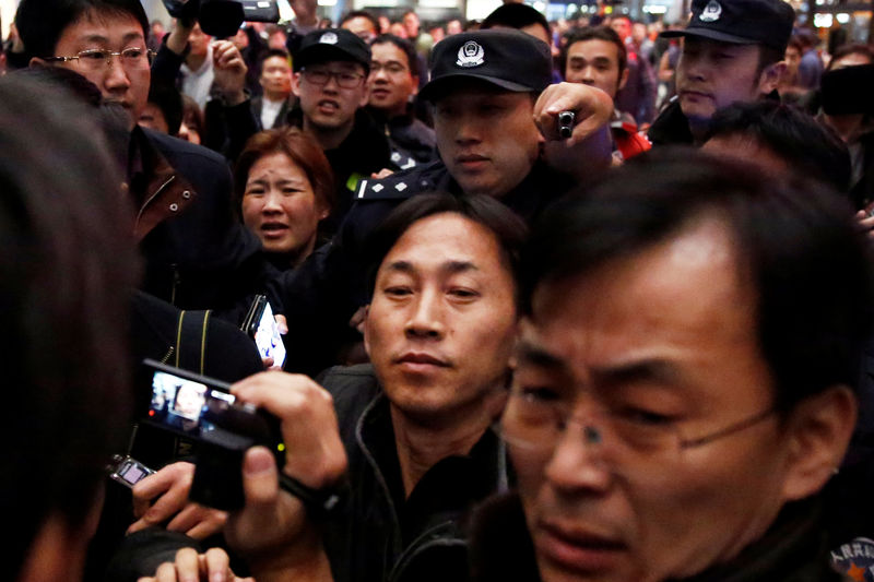 © Reuters. North Korean national Ri Jong Chol is surrounded by media after his arrival at Beijing airport