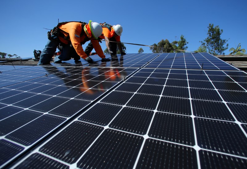 © Reuters. Solar installers from Baker Electric place solar panels on the roof of a residential home in Scripps Ranch, San Diego, California