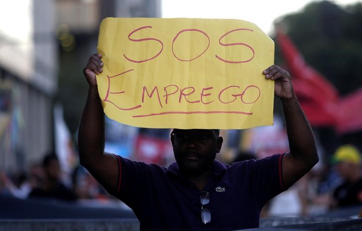 © Reuters. Homem segura cartaz "S.O.S. Emprego" no Rio de Janeiro