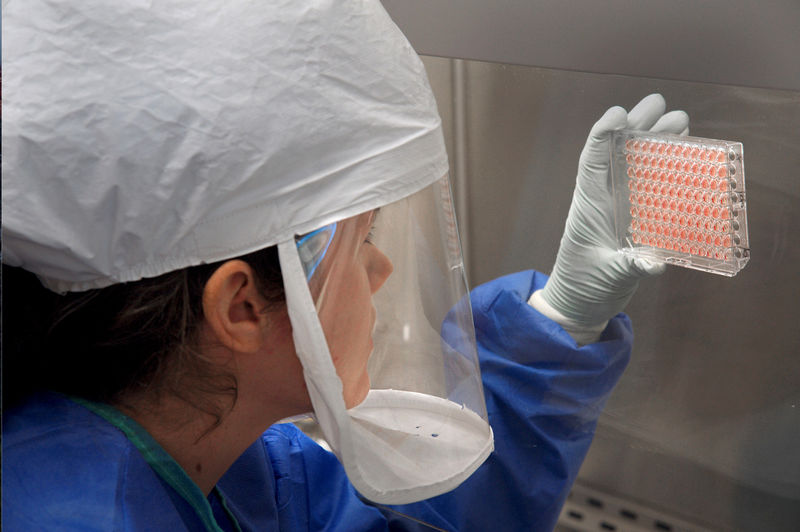 © Reuters. FILE PHOTO: A Centers for Disease Control (CDC) scientist measures the amount of H7N9 avian flu virus which was grown and harvested in an unnamed CDC laboratory