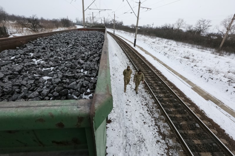 © Reuters. Activists walk along carriages loaded with coal from the occupied territories which they blocked at Kryvyi Torets station in the village of Shcherbivka