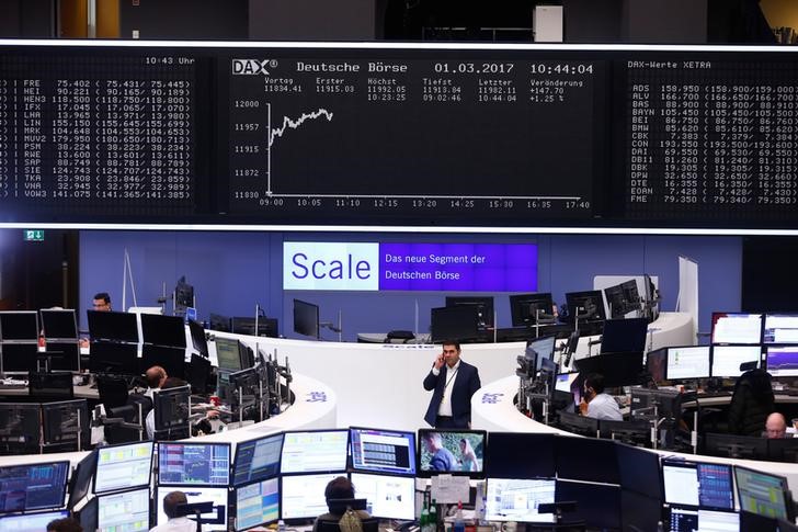 © Reuters. Traders work at their desks in front of the German share price index DAX board in Frankfurt