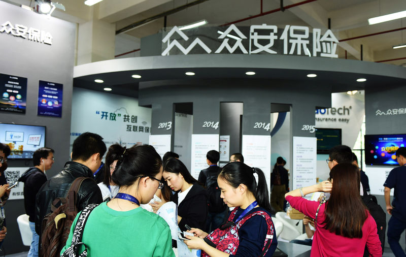 © Reuters. People visit a booth of Zhongan during an exhibition in Hangzhou