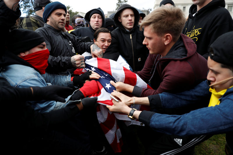 © Reuters. Counter-demonstrators (L) and supporters (R) of U.S. President Donald Trump fight for a U.S. flag during a "People 4 Trump" rally in Berkeley, California