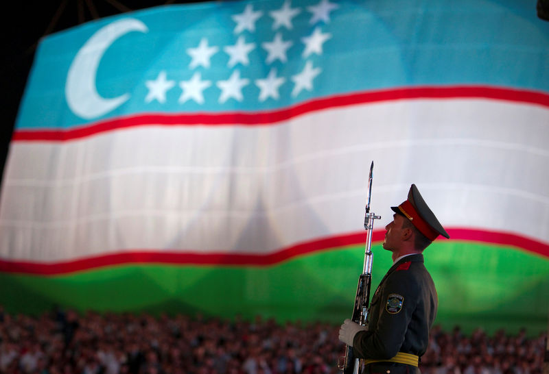 © Reuters. FILE PHOTO: A soldier stands in front of the national flag during an Independence Day celebration in Tashkent