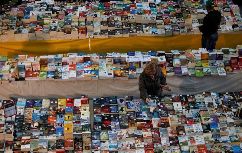 © Reuters. A passenger takes a book in a bookstore at Oriente train station in Lisbon