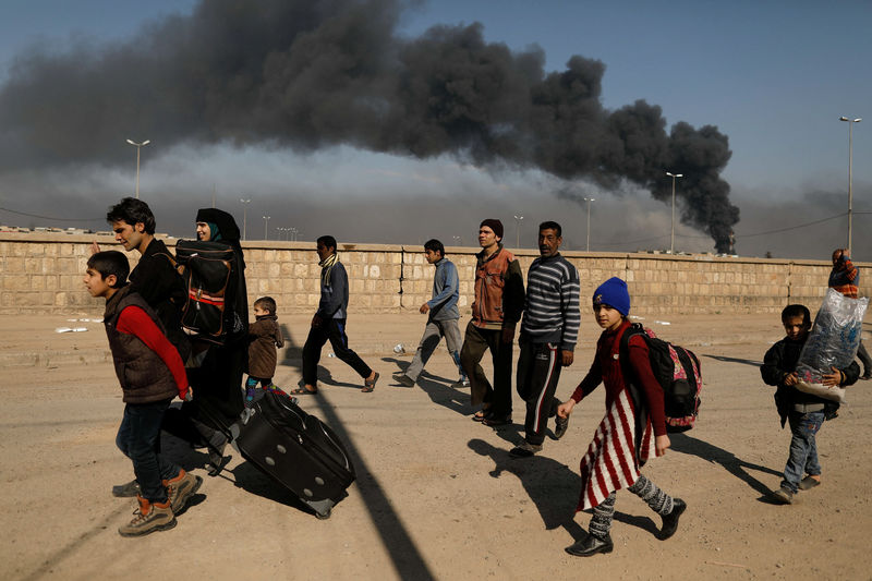 © Reuters. Iraquianos deixam suas casas durante batalhas de forças do Iraque contra militantes do Estado Islâmico no oeste de Mosul