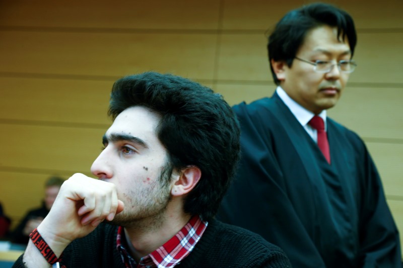 © Reuters. Syrian refugee Anas Modamani accompanied by his lawyer Chan-Jo Jun attends a court session against Facebook over a selfie with Merkel at the district court in Wuerzburg