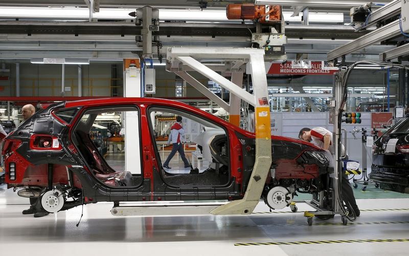 © Reuters. A worker from the SEAT factory, under the Volkswagen group, works on an engine of a SEAT Leon car, in Martorell near Barcelona