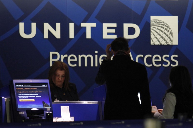 © Reuters. A worker from United attends to some customers during their check in process at Newark International airport in New Jersey