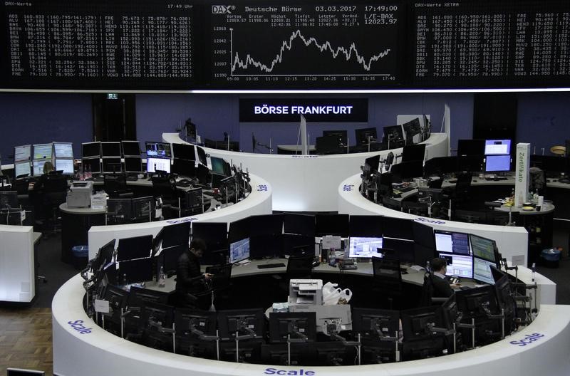 © Reuters. Traders work at their desks in front of the German share price index DAX board in Frankfurt