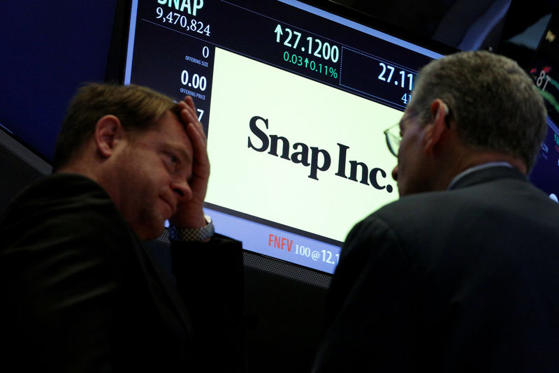 © Reuters. Traders gather at the post where Snap Inc. is traded on the floor of the NYSE