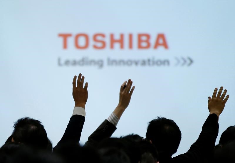 © Reuters. Reporters raise their hands for a question during a news conference by Toshiba Corp CEO Satoshi Tsunakawa and other senior sompany officials at the company's headquarters in Tokyo, Japan