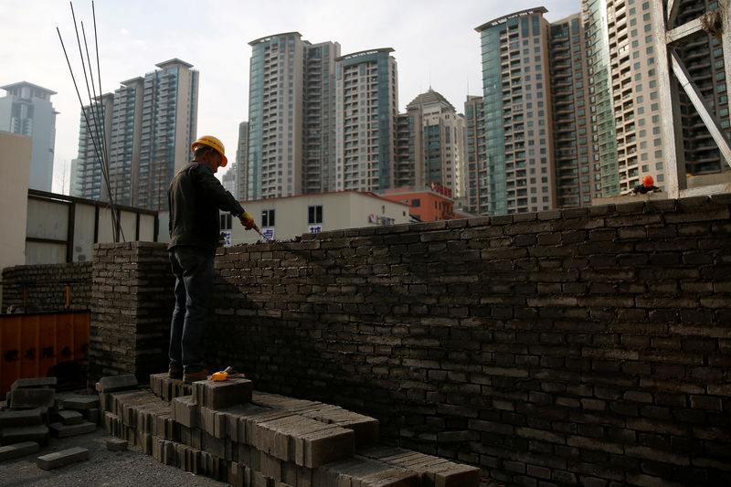 © Reuters. FILE PHOTO: A worker works at a construction site in Shanghai