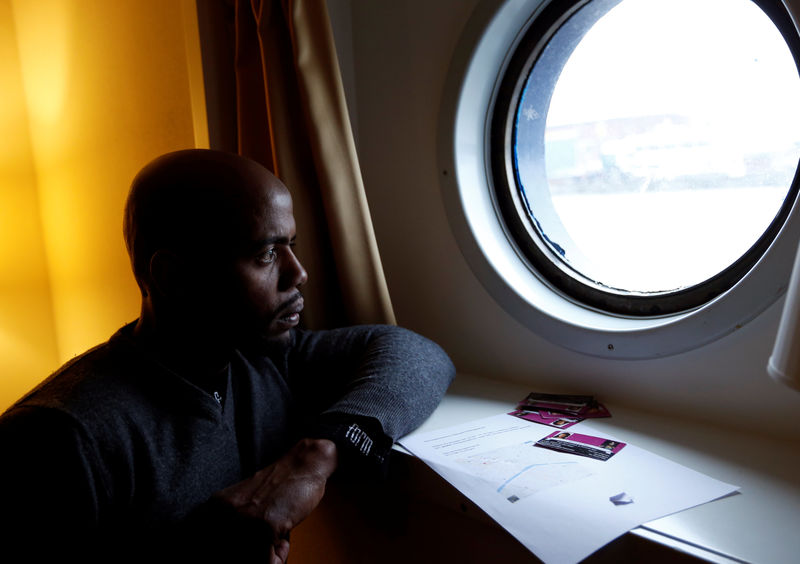 © Reuters. Sall from Guinea looks through a window of a boat cabin in a floating hotel in Groningen