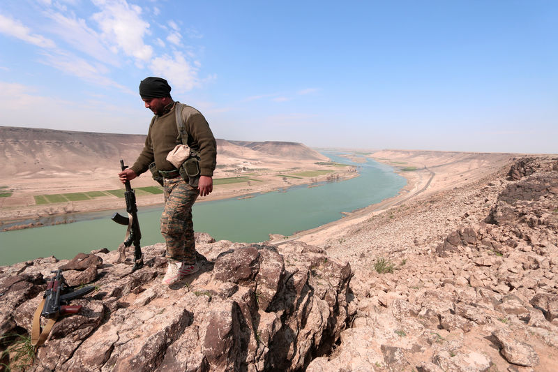 © Reuters. A Syrian Democratic Forces(SDF) fighter poses for a picture near Euphrates River, north of Raqqa city