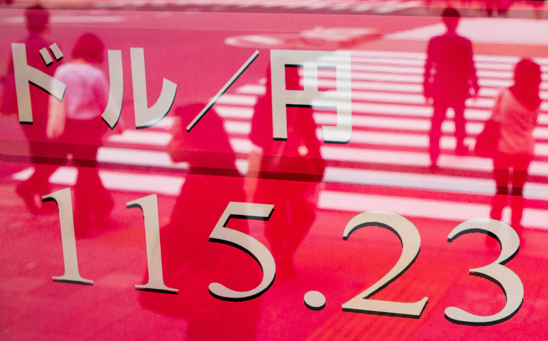 © Reuters. FILE PHOTO:  People walk past a screen displaying the dollar to yen exchange rate outside a brokerage in Tokyo