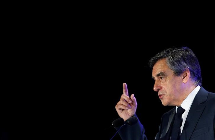 © Reuters. FILLON S'EN PREND AU "GOLDEN BOY" MACRON