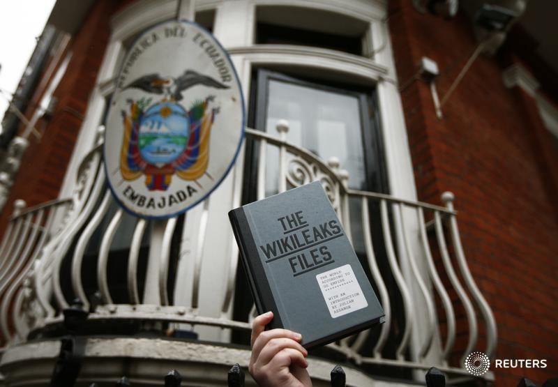 © Reuters. Сторонник основателя WikiLeaks Джулиана Ассанжа держит экземпляр книги The WikiLeaks Files у посольства Эквадора в Лондоне