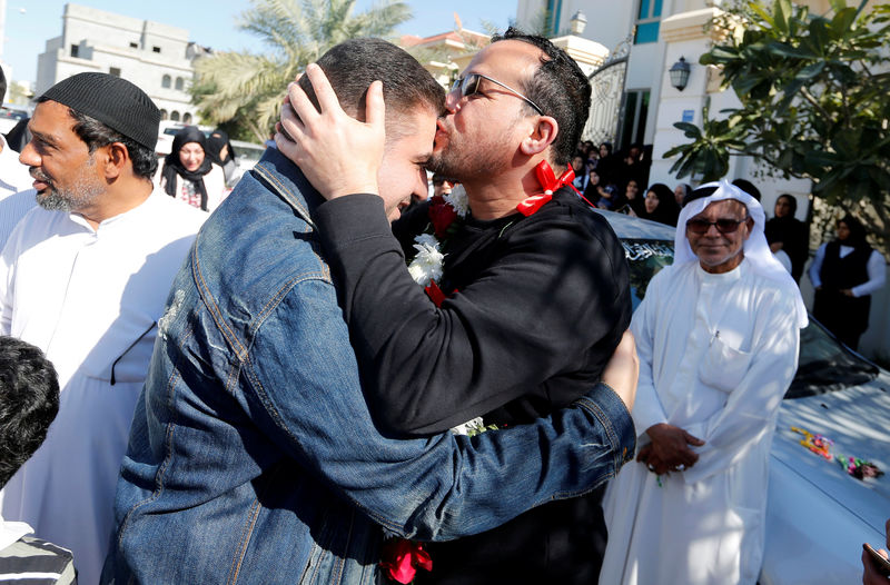 © Reuters. Ali Al-Ekri kisses his family member as he is welcomed home after completing his five-year sentence, in Manama