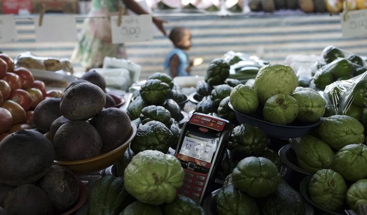 © Reuters. A machine for credit cards is seen next to groceries on a stall at Feira Livre market on the streets of Pinheiros neighbourhood in Sao Paulo