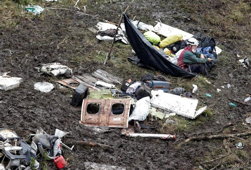 © Reuters. A rescue worker sits near the wreckage of a plane that crashed into the Colombian jungle with Brazilian soccer team Chapecoense onboard near Medellin