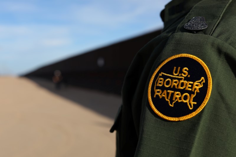 © Reuters. A U.S. border patrol agent walks along the border fence between Mexico and the United States near Calexico, California