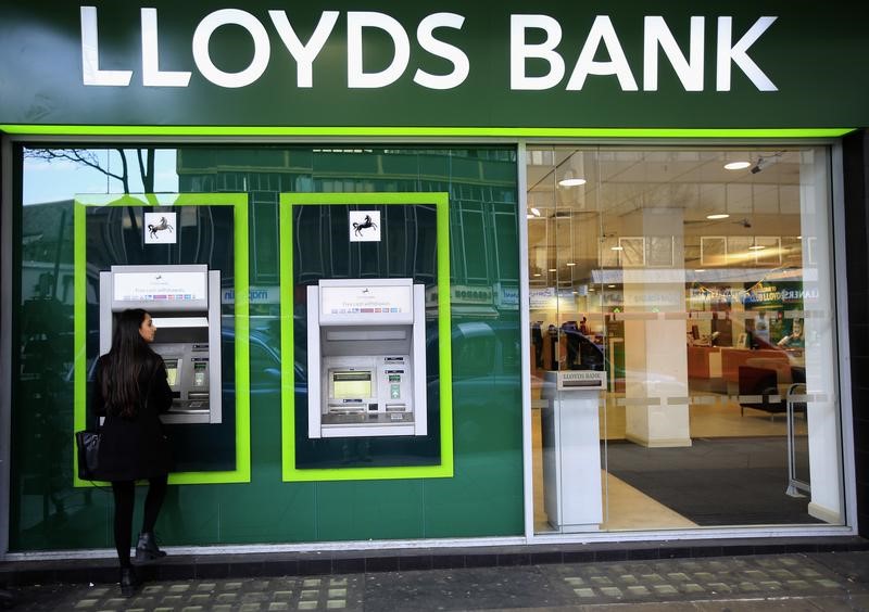 © Reuters. A woman uses a cash machine at a Lloyds Bank branch in central London
