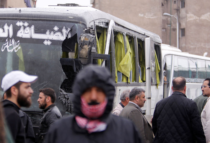 © Reuters. People inspect the damage at the site of an attack by two suicide bombers in Damascus