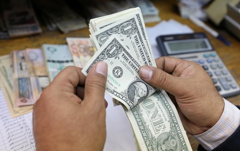 © Reuters. Мужчина пересчитывает долларовые купюры в обменном пункте в Каире
