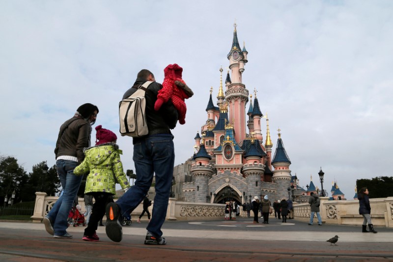 © Reuters. FILE PHOTO: Visitors walk towards the Sleeping Beauty Castle during a visit to the Disneyland Paris Resort in Marne-la-Vallee