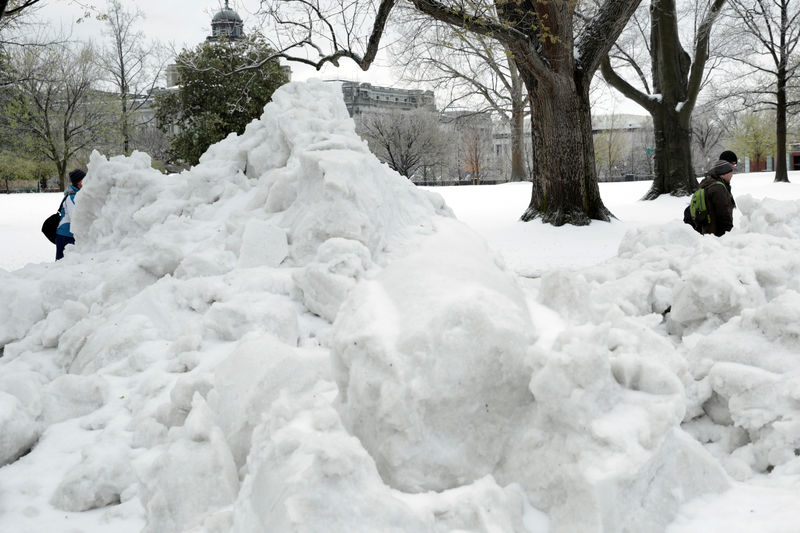 © Reuters. People walk past a pile of snow on Capitol Hill in Washington