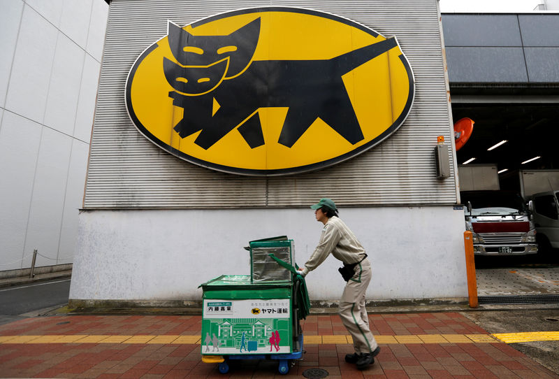 © Reuters. Deliverer of Yamato Transport Co is seen under the company's logo at a business district in Tokyo