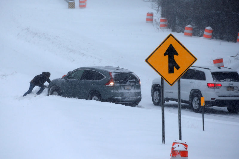 © Reuters. Homem tenta empurrar carro atolado na neve perto de New York