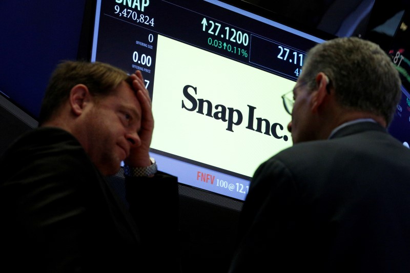 © Reuters. Traders gather at the post where Snap Inc. is traded on the floor of the NYSE