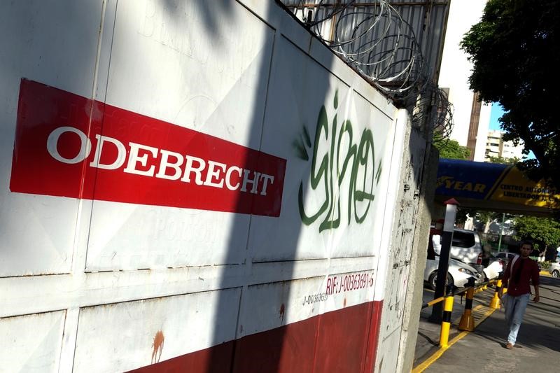 © Reuters. A man walks past the corporate logo of Odebrecht in a construction site in Caracas