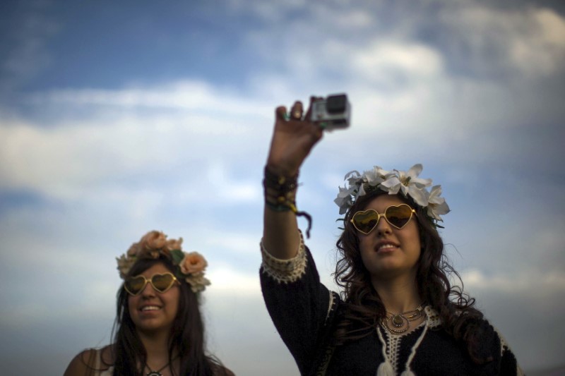 © Reuters. Women record GoPro video at the Coachella Valley Music and Arts Festival in Indio