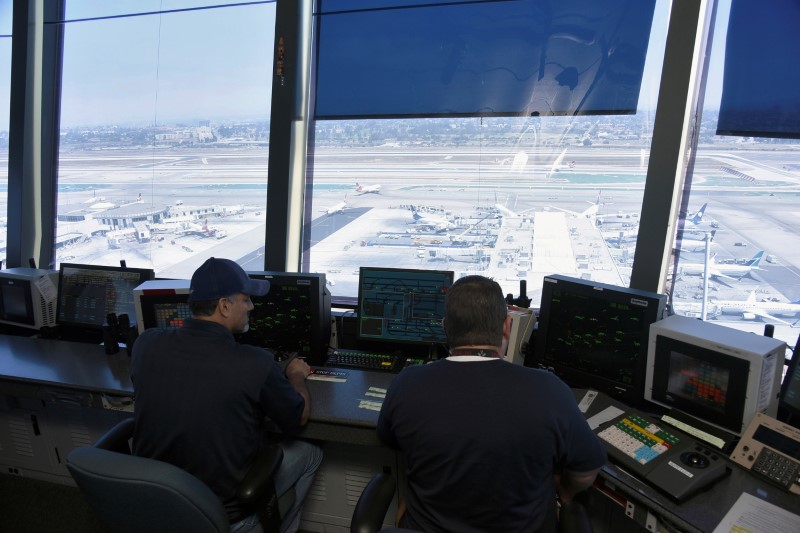 © Reuters. Air traffic controllers talk with pilots inside the control tower at Los Angeles International Airport (LAX) in  Los Angeles, California