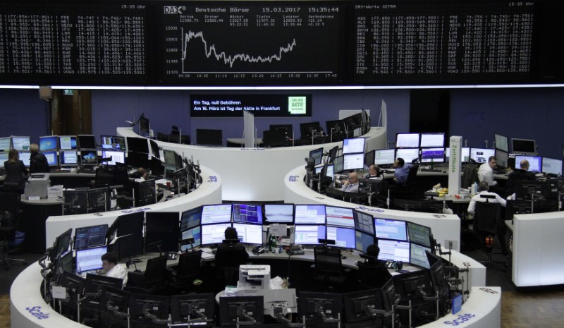 © Reuters. Traders work at their desks in front of the German share price index DAX board in Frankfurt