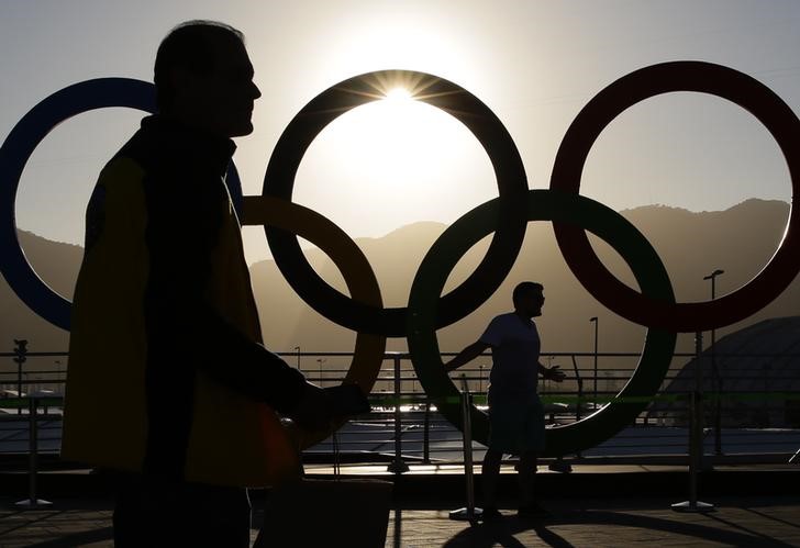 © Reuters. Pessoas posam para fotos em frente aos anéis olímpicos no Rio de Janeiro