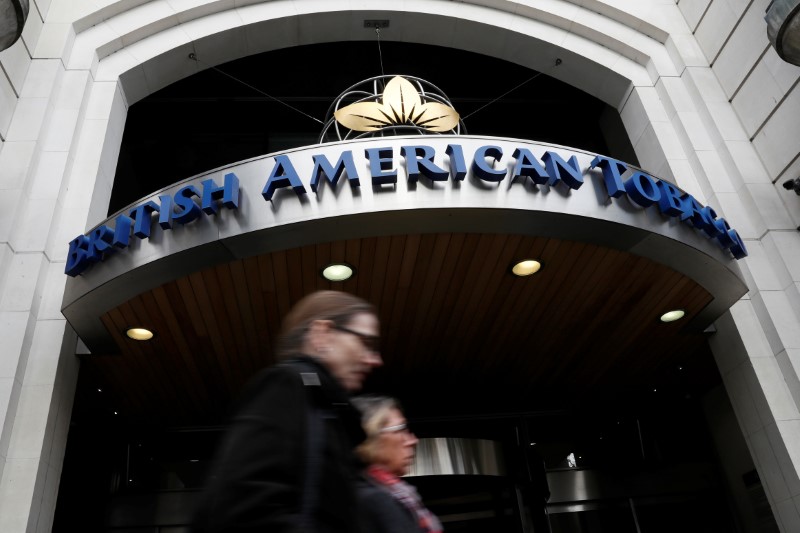 © Reuters. FILE PHOTO -  People walk past the British American Tobacco offices in London