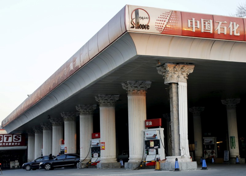 © Reuters. Cars wait to take on fuel at a Sinopec gas station in Beijing