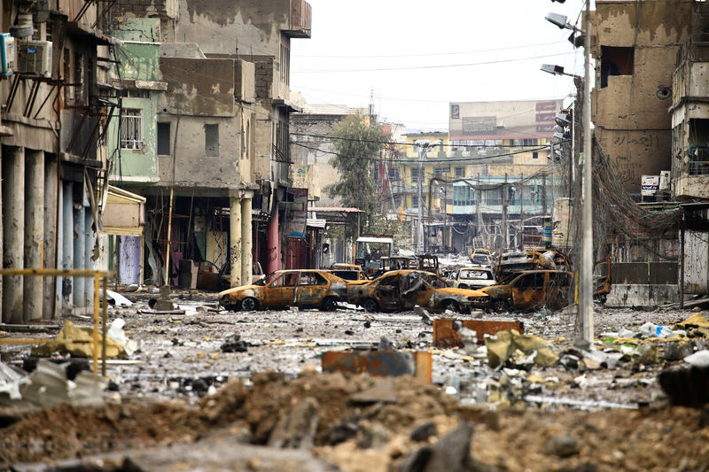 © Reuters. Cars burnt and destroyed by clashes are seen on a street during a battle between Iraqi forces and Islamic State militants, in Mosul