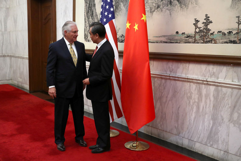 © Reuters. U.S. Secretary of State Rex Tillerson talks with Chinese Foreign Minister Wang Yi, as he arrives for a bilateral meeting at the Diaoyutai State Guesthouse in Beijing