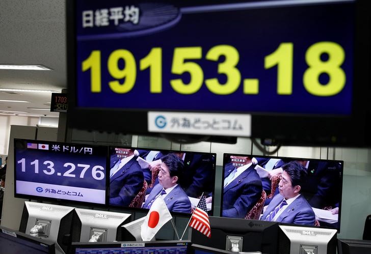 © Reuters. A TV monitor showing Japanese Prime Minister Shinzo Abe is seen next to monitors showing the Japanese yen's exchange rate against the U.S. dollar and Nikkei average at a foreign exchange trading company in Tokyo