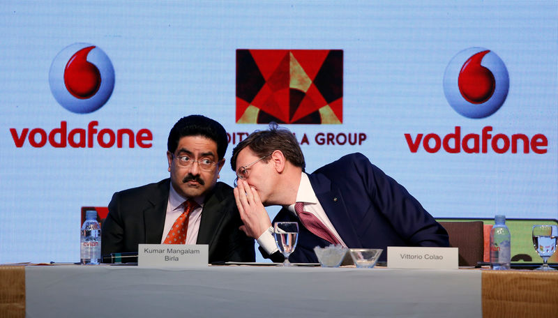 © Reuters. Kumar Mangalam Birla, chairman of Aditya Birla Group, listens to Vittorio Colao, CEO of Vodafone Group, during a news conference in Mumbai