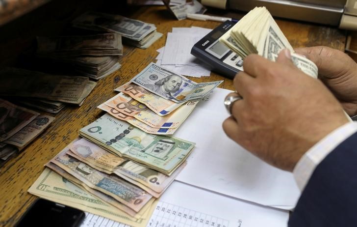 © Reuters. A man counts U.S dollar and Euro banknotes at a money exchange office in central Cairo