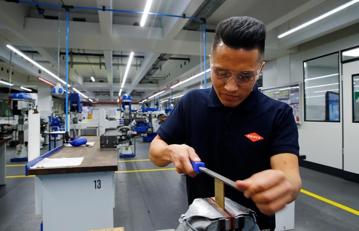 © Reuters. Trainee Hosseini from Afghanistan works with a rasp at the training workshop of German tools maker Knipex in Wuppertal