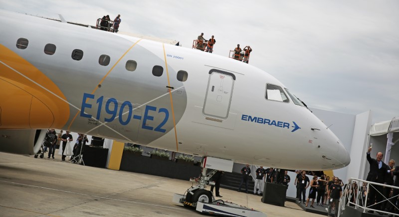 © Reuters. Brazilian aircraft maker Embraer's CEO Curado salutes workers next to an new Embraer E190-E2  during its unveil in Sao Jose dos Campos