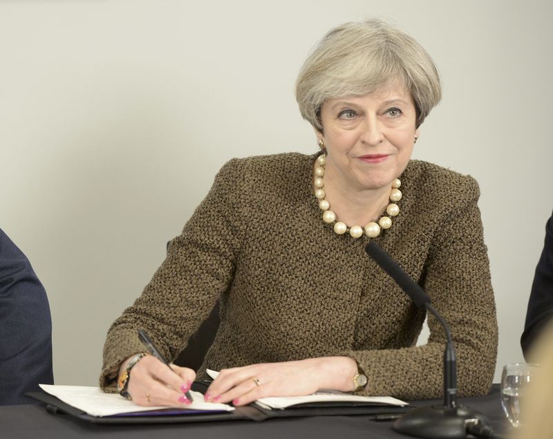 © Reuters. Britain's Prime Minister Theresa May signs a Swansea City deal during a meeting at the Liberty Stadium in Swansea